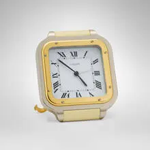 Les Must de Cartier Santos travel alarm clock by Claude Moliterni, c. 1985, stainless steel, lacquered metal, gold-plated metal, synthetic blue spinel, sold Oct 2026