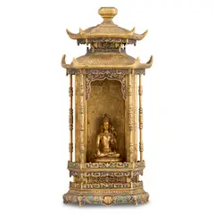 This finely crafted imperial gilt-bronze shrine is conceived in the form of a traditional Chinese pavilion with double-eaved roofs, its soaring upturned eaves imparting an air of dignity and elegance. The exterior is richly gilded throughout and meticulously chased with scrolling cloud and floral motifs that flow seamlessly across its surfaces. The base and eaves are further embellished with enamel decoration, the vibrant colours providing a striking contrast to the lustrous gilding. Executed with exceptional precision and refinement, the shrine exemplifies the exacting standards and aesthetic sophistication of Qing imperial workmanship. by Qing Dynasty A Chinese Gilt-Bronze And Enamel Buddhist Shrine Enshrining A Zanabazar-Style Figure, sculpture, sold Oct 2026