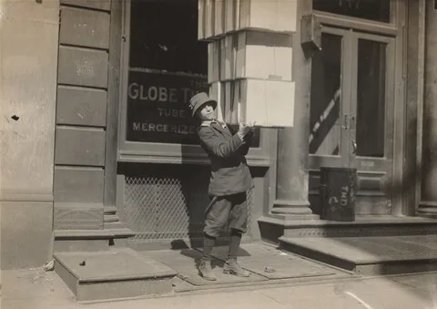 Lewis Hine, Wagon boy or "tail boy" helping to load the wagon