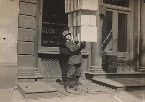 Lewis Hine, Wagon boy or "tail boy" helping to load the wagon