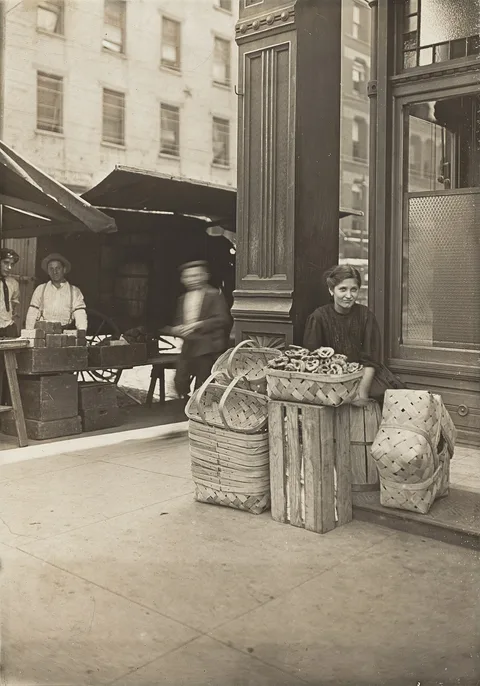 Lewis Hine, Lena Lochiavo - 11 years old, basket (and pretzel) seller, at Sixth Street Market in front of saloon entrance, Cincinnati, Ohio