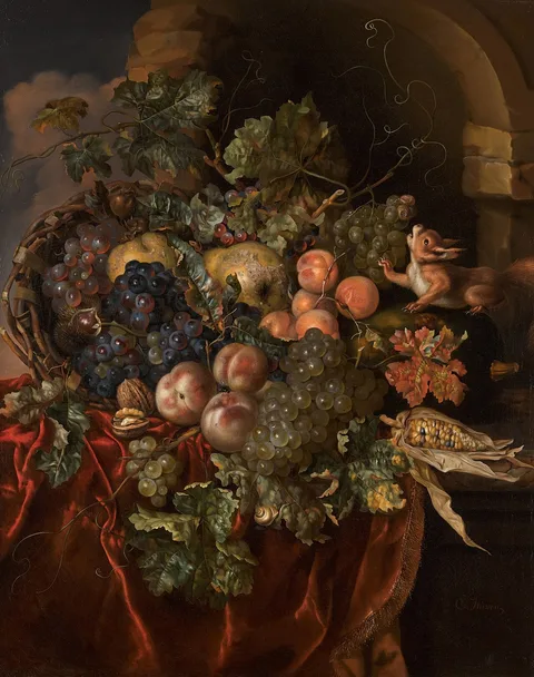 Ernst Stuven, Still life of grapes, peaches, apricots, pears, walnuts and chestnuts, with a squirrel, on a ledge partially draped with a red cloth in a ruined stone niche