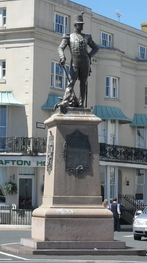 William Goscombe John, Bronze statue of soldier of Royal Sussex Regiment, in full dress uniform with plumed shako, and with drawn sword; cannon to rear